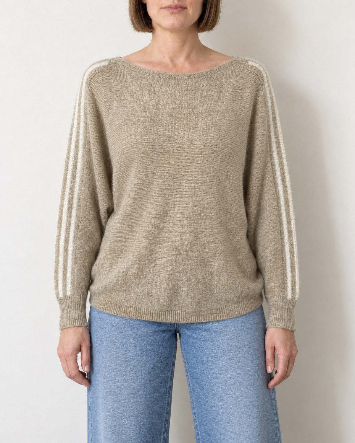 Maglia scollo a barca a pipistrello beige indossata con jeans chiari, vista frontale