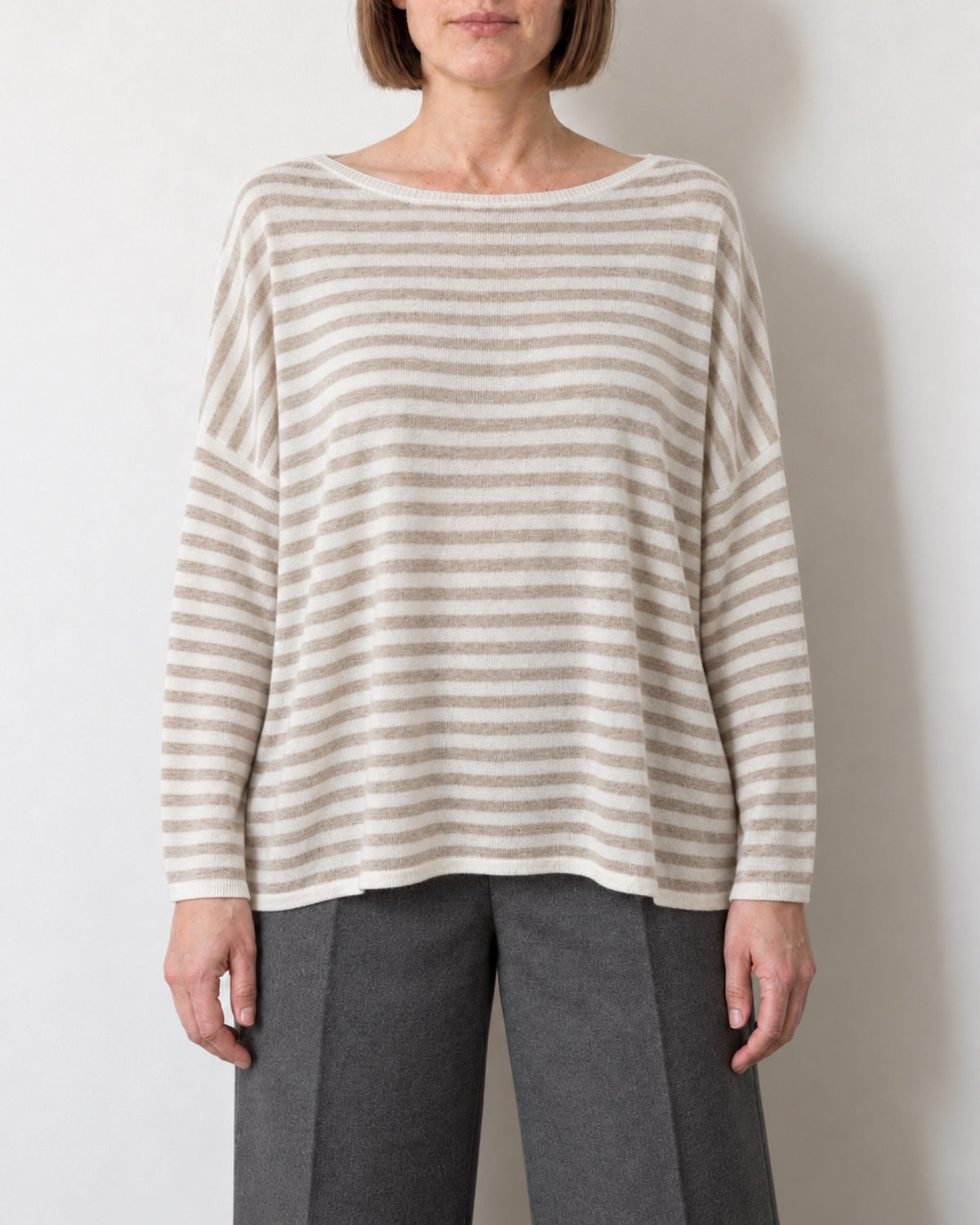 Maglia a righe oversize con maniche a pipistrello indossata con pantaloni antracite, vista frontale