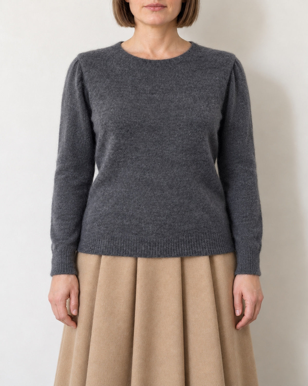 Maglia con maniche a sbuffo grigio antracite indossata con gonna color cammello, vista frontale