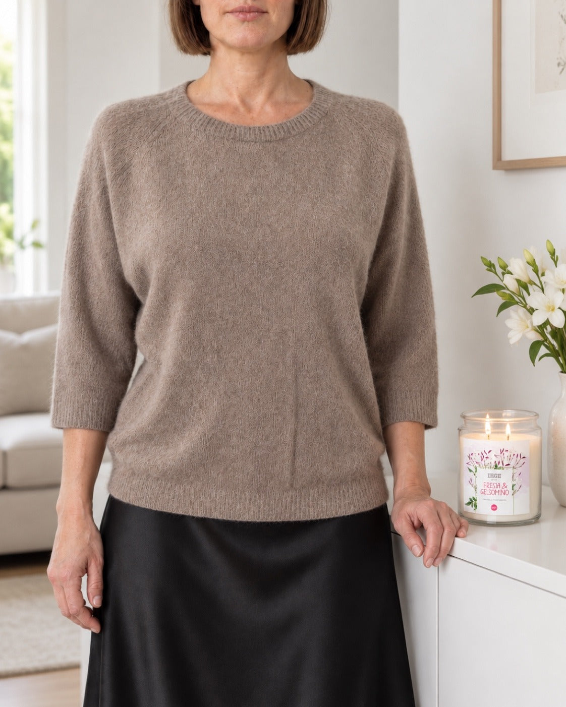Maglia tortora in alpaca a maniche tre quarti indossata con gonna nera in soggiorno
