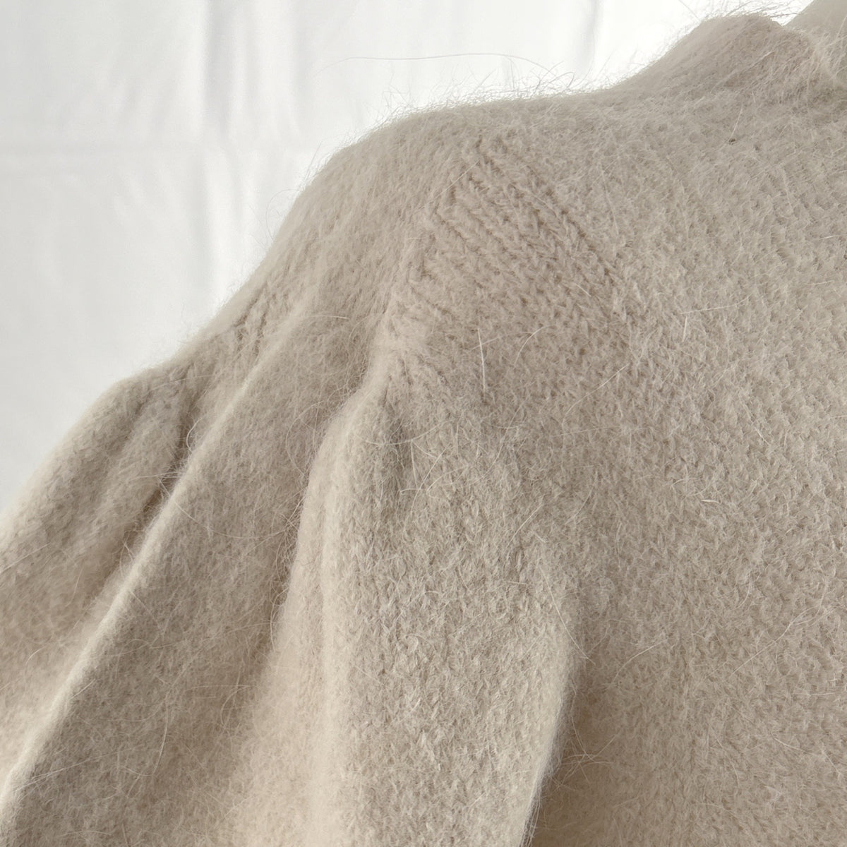 Maglia con maniche a sbuffo beige, dettaglio dello sbuffo alla spalla