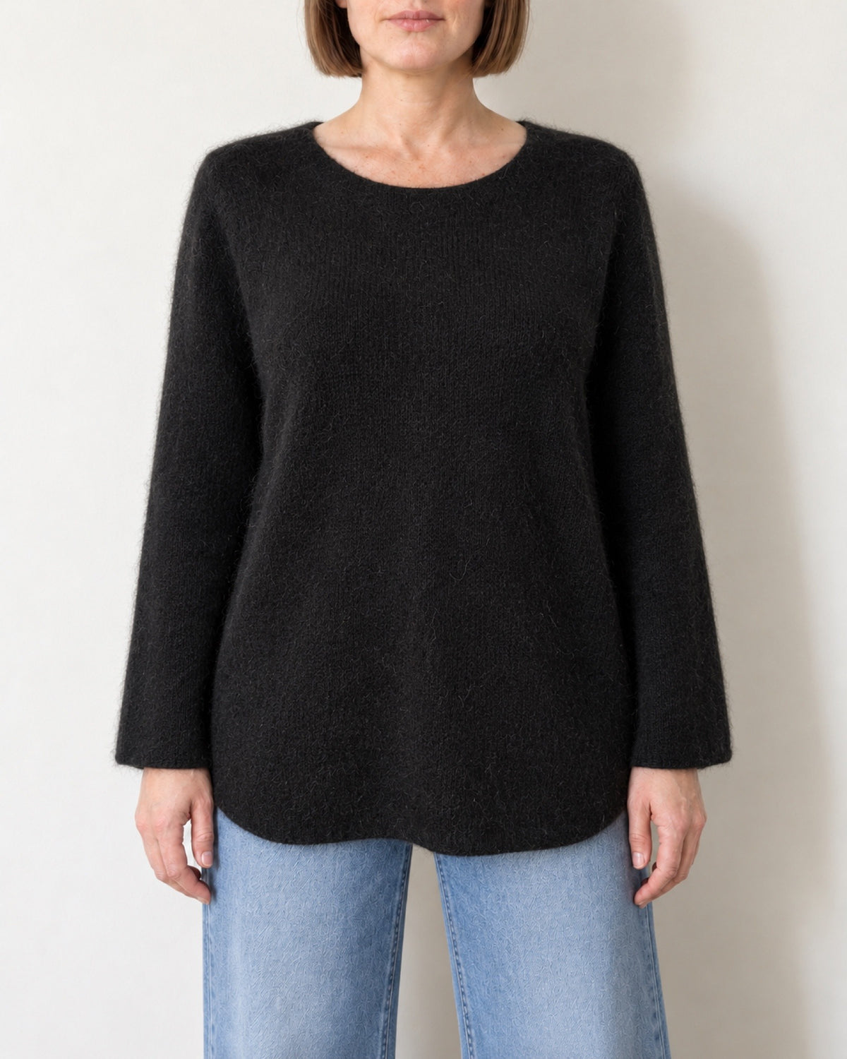Maglione oversize nero indossato con jeans chiari, vista frontale