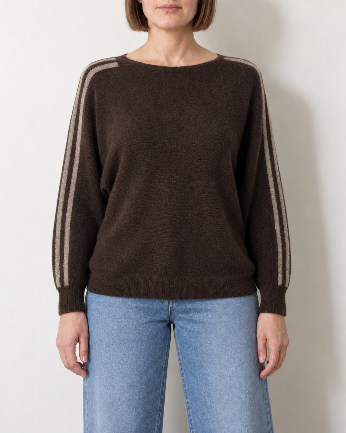 Maglia scollo a barca a pipistrello marrone indossata con jeans chiari, vista frontale