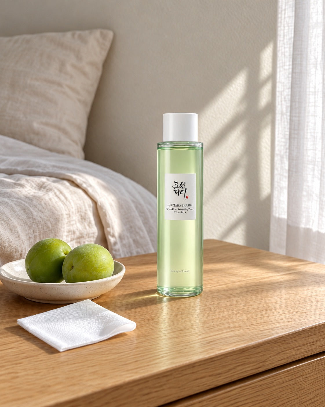 Tonico alla prugna verde Beauty of Joseon su toeletta in rovere, con due prugne