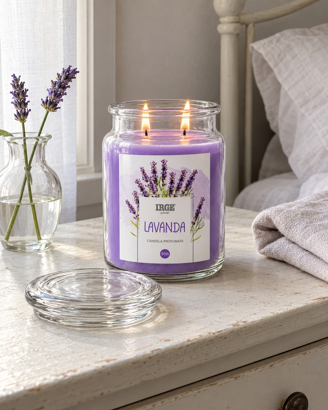 Candela alla lavanda su mensola accanto al letto, con steli di lavanda