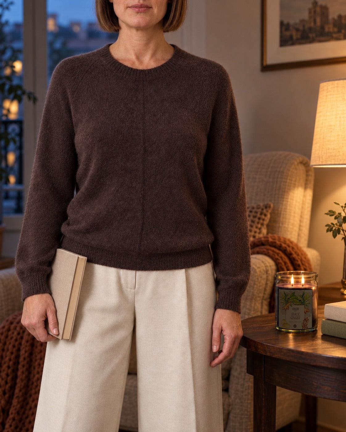 Maglione marrone in alpaca indossato con pantaloni ecru la sera in salotto