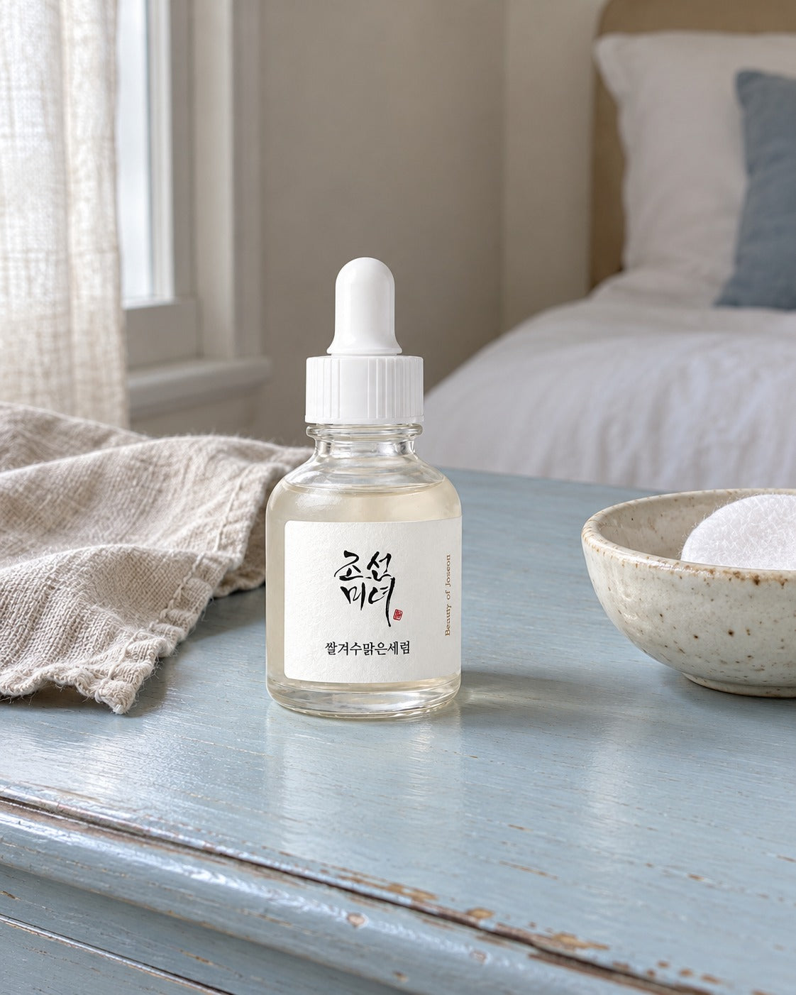 Siero Glow Deep Beauty of Joseon su toeletta azzurra, accanto a un dischetto
