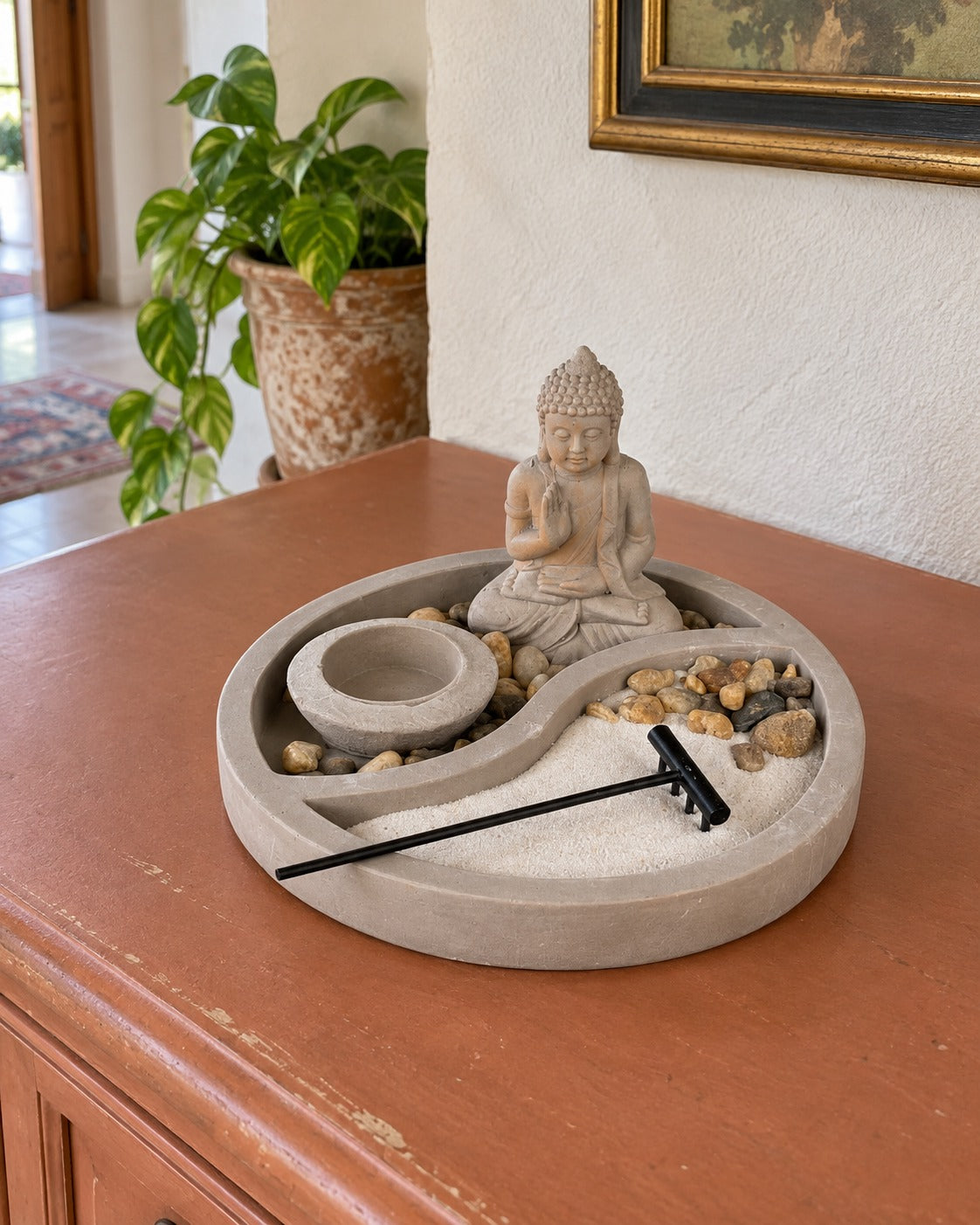 Set giardino zen con statua di Buddha su consolle color terracotta, con pianta