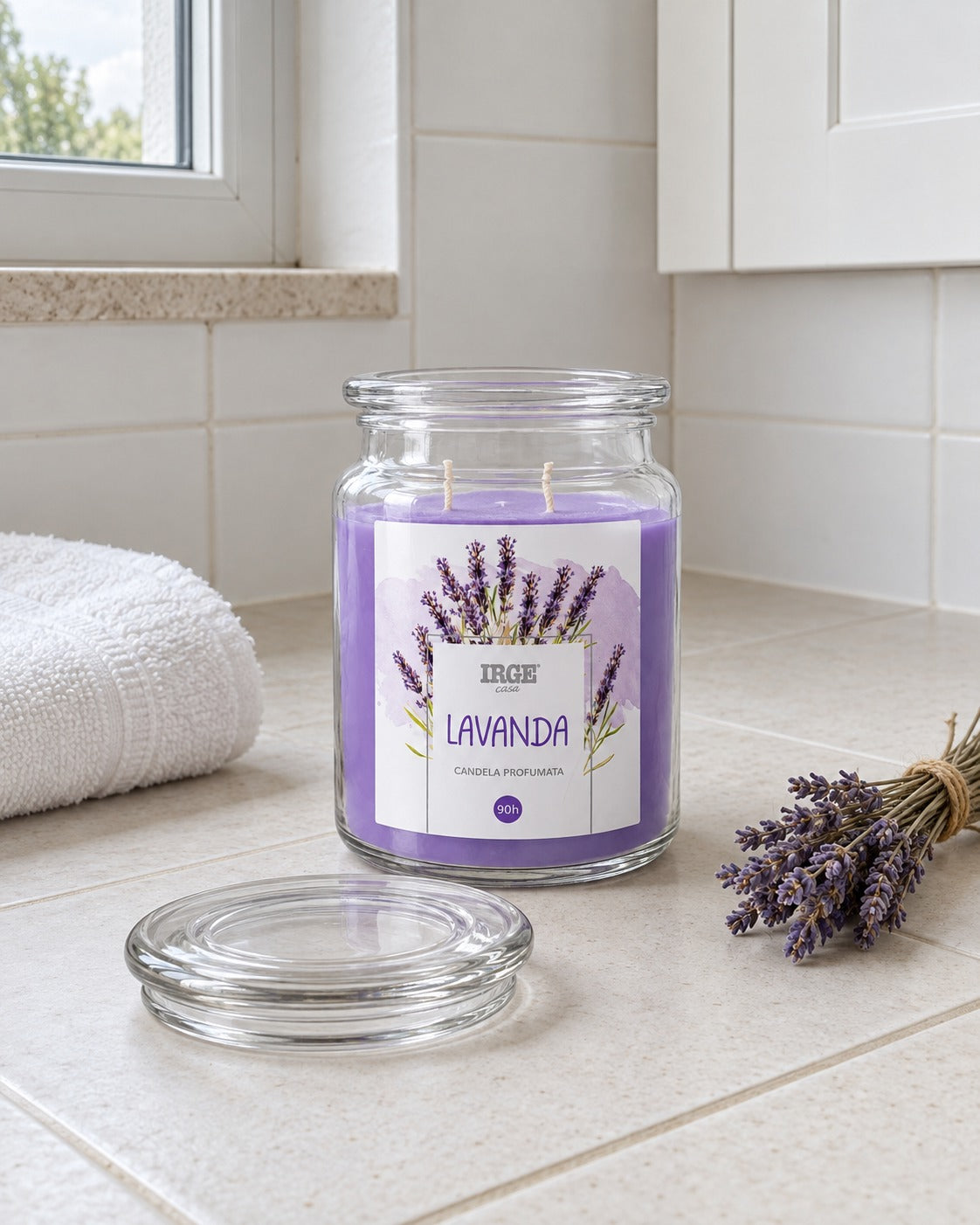 Candela alla lavanda sul piano della lavanderia, con un mazzo di steli essiccati