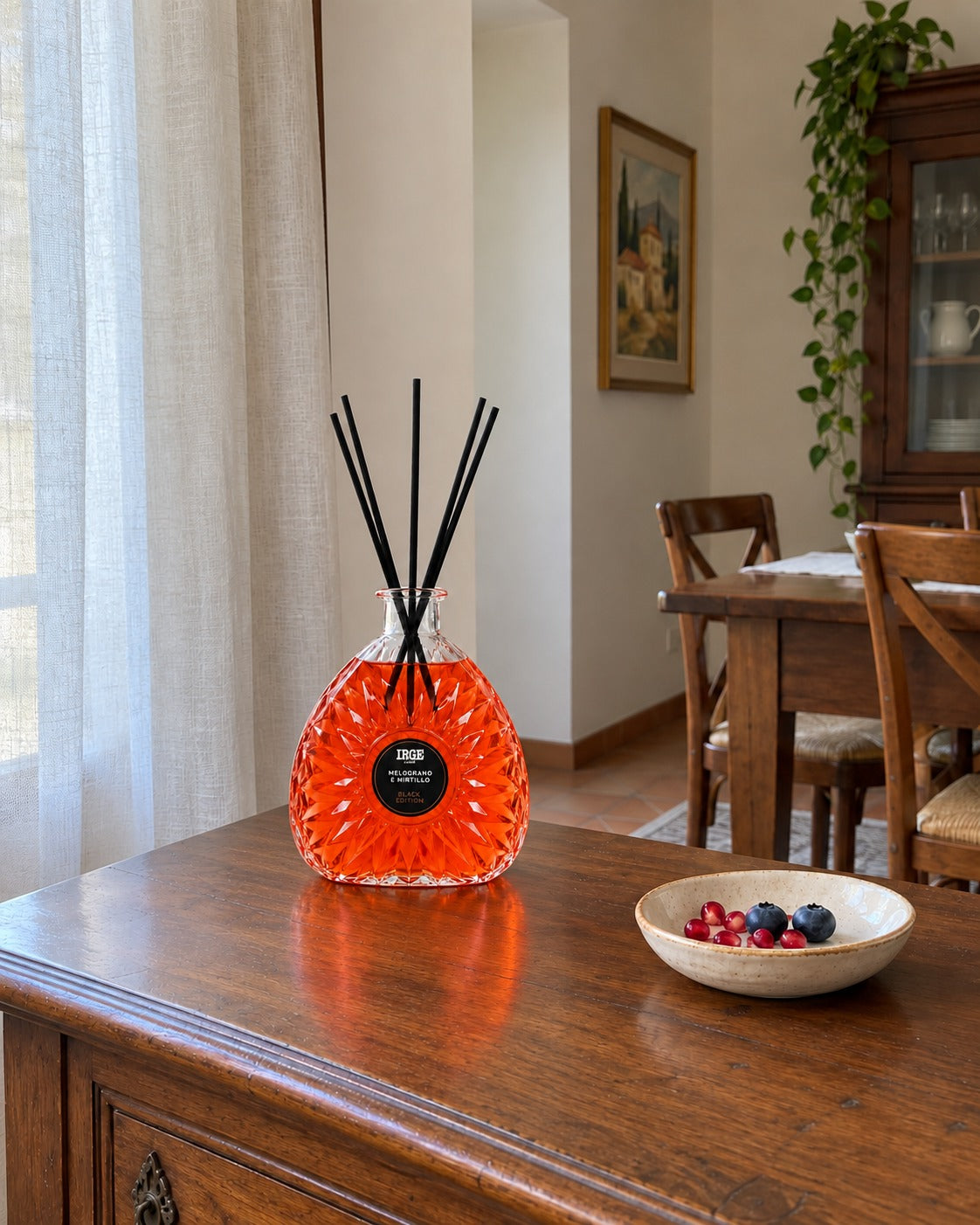 Diffusore al melograno e mirtillo su credenza in castagno, con semi e mirtilli