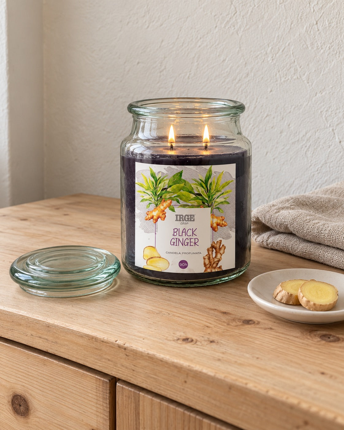 Candela allo zenzero nero su credenza in pino, con fettine di zenzero